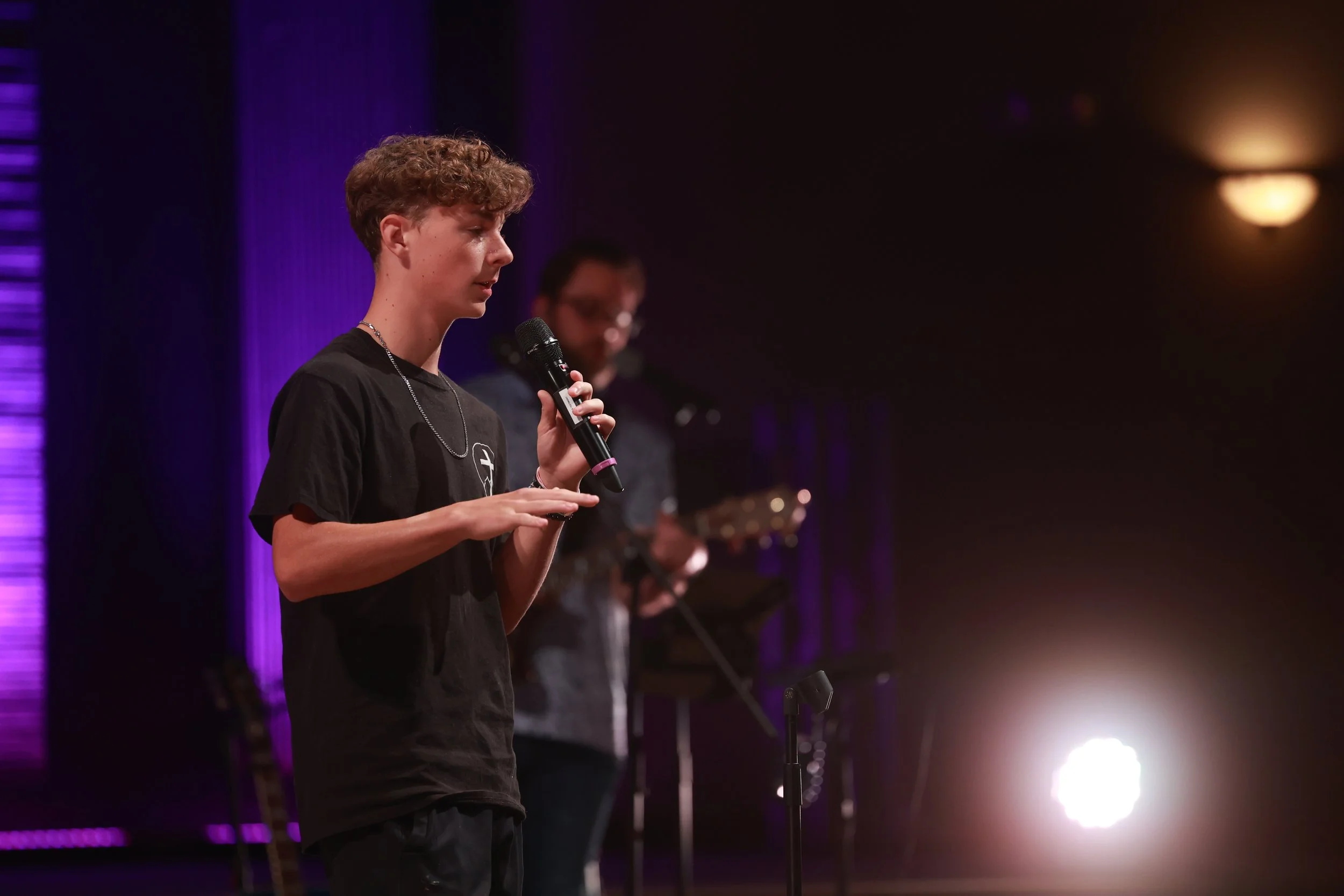Student leading worship on stage